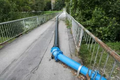 Za začasno namestitev nadomestne kanalizacijske cevi na poškodovanem mostu je poskrbela Civilna zaščita Mestne občine Kranj v sodelovanju z Gasilsko reševalno službo Kranj. / Foto: Tina Dokl